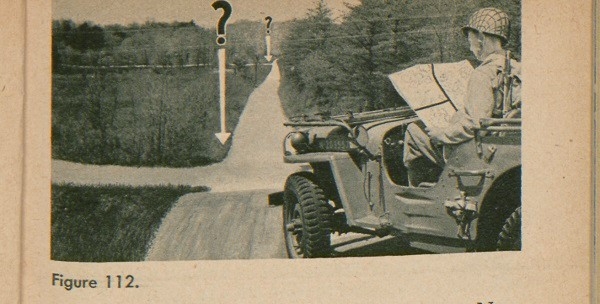 Figure 112: A soldier in a car looking at a map to determine direction.