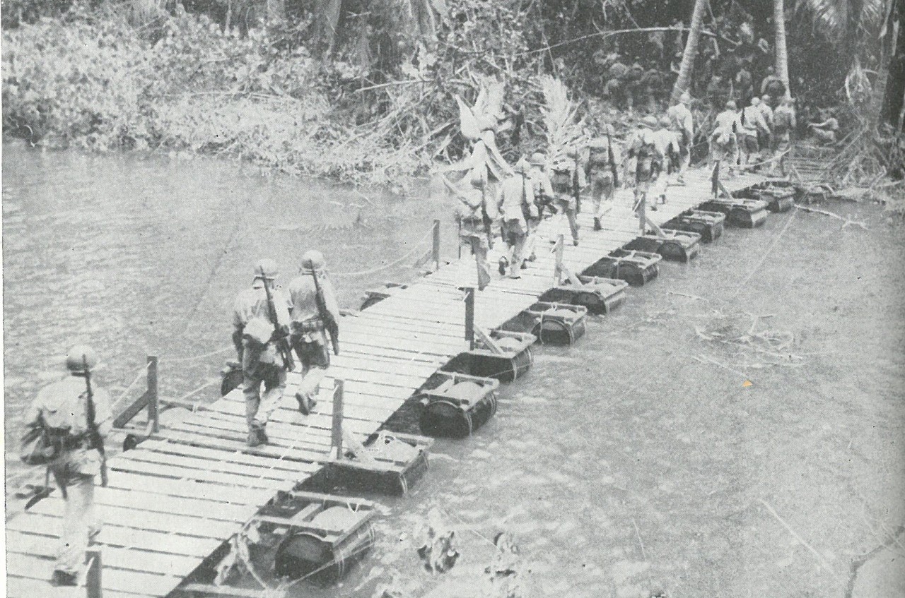 PATROLLING INTENSIFIED as it became evident that this was the only effective method of divining Japanese intentions under Guadalcanal jungle cover. This Marine unit is crossing the Matanikau River footbridge.