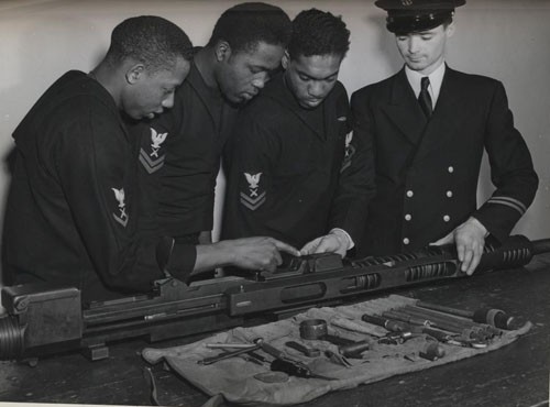 "Under the direction of Chief Gunner's Mate Rex Ashley, USN, three gunner's mates assemble and study a 20-mm. gun, the type which they will man aboard the DE [destroyer escort]. Trainees at Norfolk are (left to right) Albert A. Davis, Gunner's Mate Second Class, and Warrren Vincent, Gunner's Mate Second Class. [Only two gunner's mates are identified in caption.] 