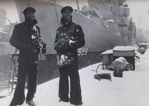 "'What's a little snow?' laugh two members of the predominantly Negro crew of the USS Mason as they stand proudly beside the bow of their new destroyer escort vessel, commissioned at Boston Navy Yard today. Eventually, the entire crew of this ship will be Negroes. [Released: First Naval District, 20 March 1944.] 
