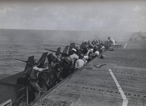 "'Negroes train sights on Japs at Saipan' - Under the direction of a gunnery officer, US Navy enlisted men pour lead at Jap planes attacking one of the aircraft carriers in the Navy Task Force raiding the Jap base of Saipan in the Marianas on 17 February 1944."