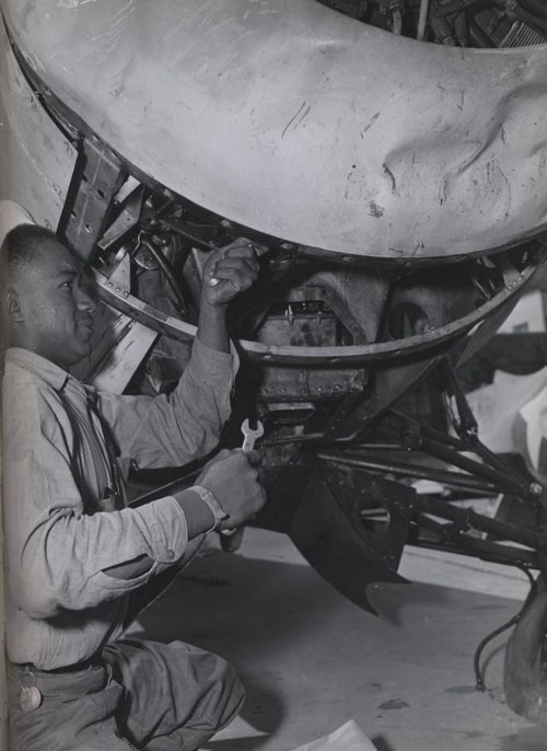 "Lattes Whitted, Seaman Second Class, helps to repair a damaged ship at the US Naval Air Station, Seattle, Washington."