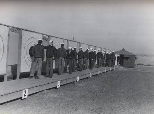 "Tabulation of scores of Naval Air Station Pasco, Washington sailors. Men pointing to targets are ordnance instructors."