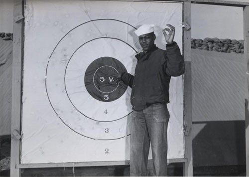 "Naval Air Station Paco, Washington, bluejacket C. Williams, Seaman Second Class, USNR, checking his shooting pattern at the outdoor range on the station."