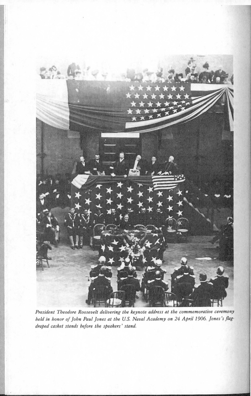 President Theodore Roosevelt delivering the keynote address at the commemorative ceremony held in honor of John Paul Jones at the US Naval Academy on 24 April 1906. Jone's flag draped casket stands before the speakers' stand.