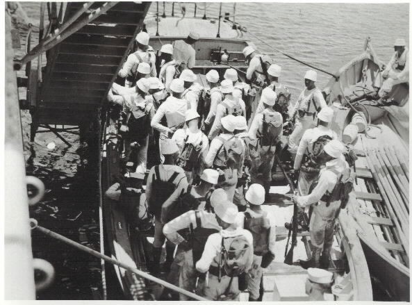 USS Houston (CA-30), ship's landing force reembarks from a motor launch, after exercises ashore at Dumanquilas Bay, Mindanao, circa 1931-33; note whale boat alongside. Collection of Lt. Oscar W. Levy, USN (SC), RET, Naval Historical Center, Photographic Branch #NH 94182.
