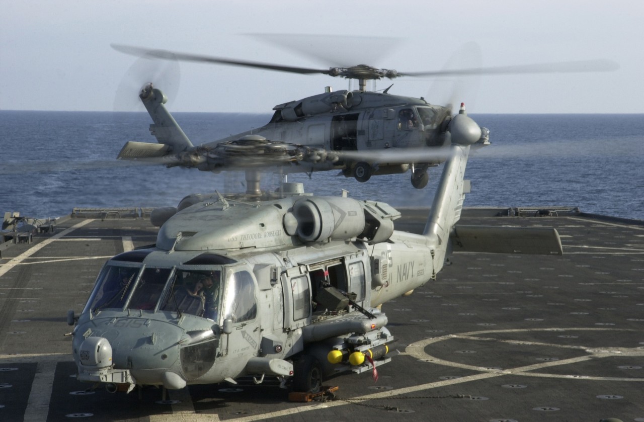 jpeg showing two HH-60H Seahawk helicopters from the Dragon Slayers of Helicopter Anti-Submarine Squadron One One (HS-11) lift off from the flight deck of USS Shreveport.