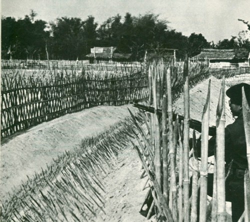Image - A guard patrols the defenses of a fortified village protected by sharpened bamboo stakes.