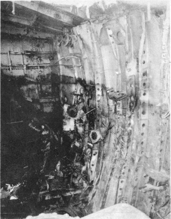 Photo 12: Damage to after port side of bulkhead 86-1/2. Note top of bulkhead pulled away from main deck.