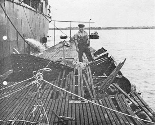 Photo 9-2: SCAMP (SS277). Bomb damage to superstructure. Alongside TANGIER (AV8), Seeadler Harbor, Admiralty Islands.
