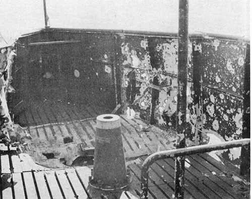 Photo 12-2: GRAMPUS (SS207). View showing fragmentation damage. Projectile is believed to have detonated approximately over the outboard engine air induction valve about two feet above the cigarette deck.