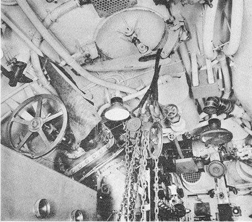 Photo 5-8: KINGFISH (SS234). View showing chain fall rig used for securing leakage around air induction hull flapper valve at frame 92-1/2 in the after engine room.
