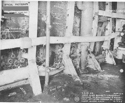 Photo 2: Fragment holes resulting from bomb No. 1. Note torn degaussing cables and buckled beam brackets.