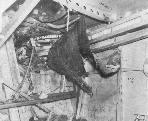Photo E-5: First hit. Compartment D-419-A, starboard after corner looking outboard. Note bomb hole in third deck and shoring and mattresses used to stop leak in shell just below the fourth deck.