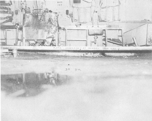 Photo E-8: First hit. Compartment D-303-1L looking forward showing deflection of third deck.