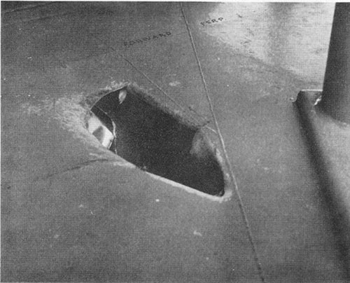 Photo F-2: First hit. Bomb passage hole in port side of forecastle deck.