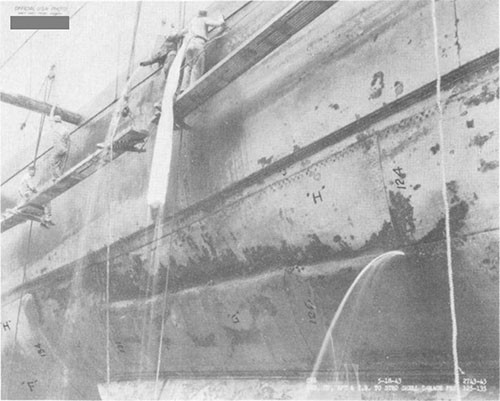 Photo F-11: First near-miss. Starboard side frames 123-135 in way of detonation. Note wooden plugs driven into rivet holes by divers.