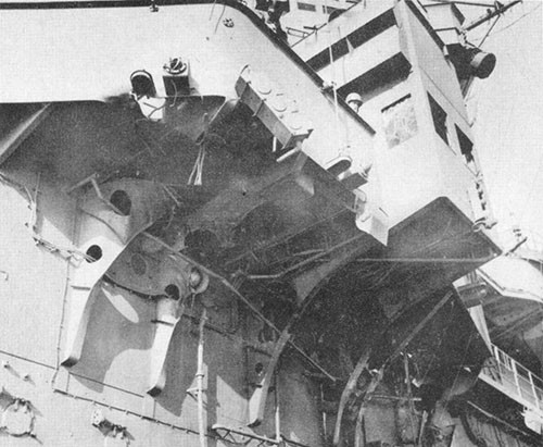 Photo H-2: Dud hit. Port side of island and navigating bridge showing brackets broken by passage of bomb.