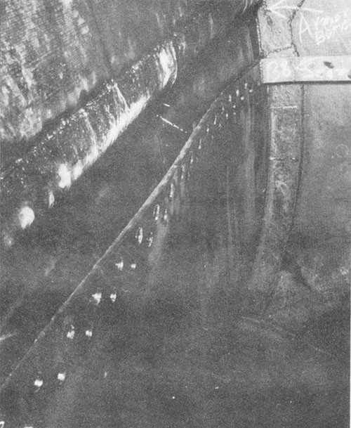 Photo I-3: First near-miss. Riveted seam below armor belt inside blister tank D-54-F, ruptured a: a result of bomb detonation.