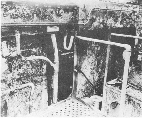 Photo C-2: Charred paint on bulkhead, port gun gallery. Archway and ladder are between frames 140 and 141. Phomene accumulator at extreme left.