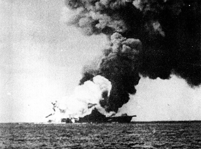 Photo 13: 19 March Action. A tremendous explosion. Note extent of high order detonation white smoke. Rockets and other pyrotechnics are distinctly visible at stern.