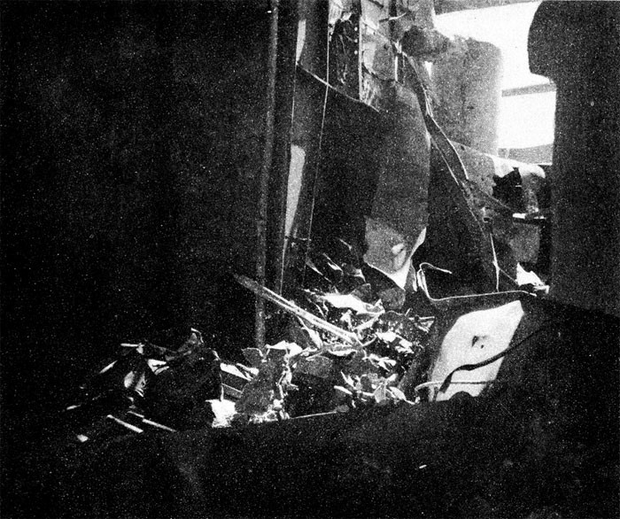 Photo 30: 19 March Action. Looking to port and up from hangar to the platform for Nos. 6 and 8 5-inch guns on port quarter. Large hole blown in gallery deck space by bomb.