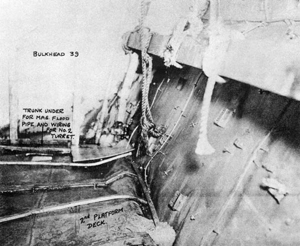Photo No. 9: A-512-M, looking aft. The broken flooding piping is under the deck between frames 38 and 39. Note bulge in deck and crushed structure in corner. Flooding came up through deck here.