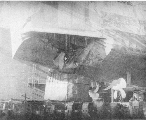 Photo No. 17: View of torpedo damage to starboard section of stern in drydock ABSD-2 at Manus. Note damage to rudder. Temporary above-water repairs were installed at Ulithi.