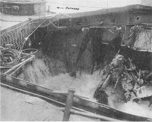 Photo No. 19: View of damage to the hangar space while en route to Ulithi. Note the upward distortion of the starboard side of the main deck.