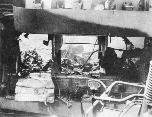 View of damage to hangar deck seen through blown-out side of hangar. Note crumpled area of hangar deck centered at about frame 78.