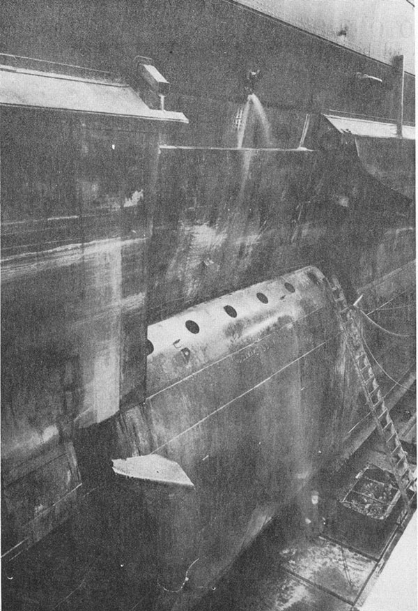 Photo 9: General view of temporary patch on arrival at Puget Sound looking aft and shoving plating peeled back action of the sea.