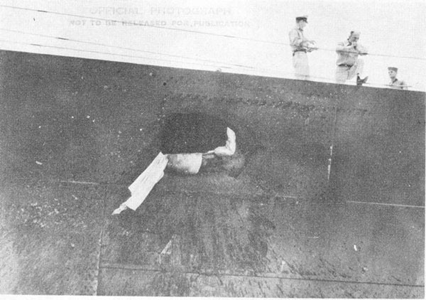 Photo 1: Hit No. 2. Hole blown in starboard sheer strake at frame 30. Note patch plates which were installed over smaller holes below sheer strake.
