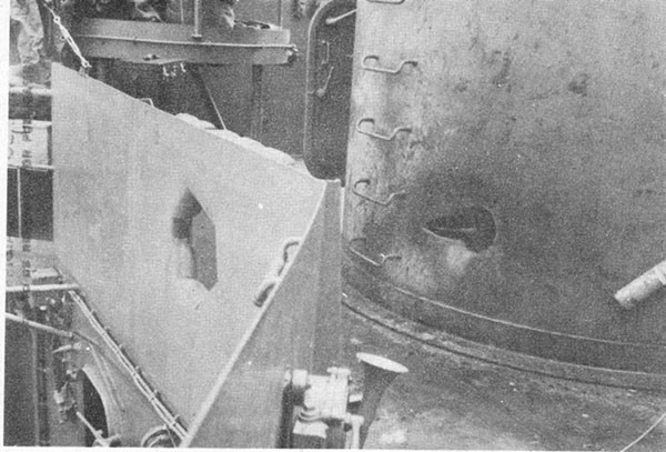 Photo 6: Hit No. 6. Projectile holes through starboard splinter shield and into 5-inch secondary battery director foundation.