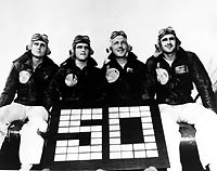 Fighter Squadron Nine (VF-9) Aces. Pose with a sign signifying their fifty victories over Japanese aircraft. Probably taken on board USS Yorktown (CV-10) at the end of the squadron's combat zone tour, circa Spring 1945.Aviators shown are (left to...