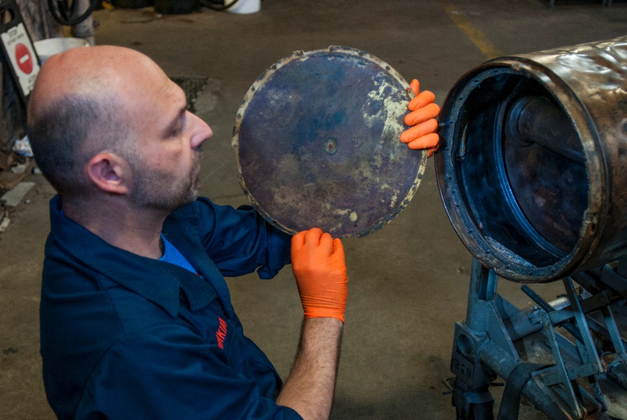 Paul Mardikian, a conservator with TerraMare Conservation and SEARCH, shows how the forward end of the middle-body section would have been sealed on the conserved Howell Mark I Torpedo No. 24