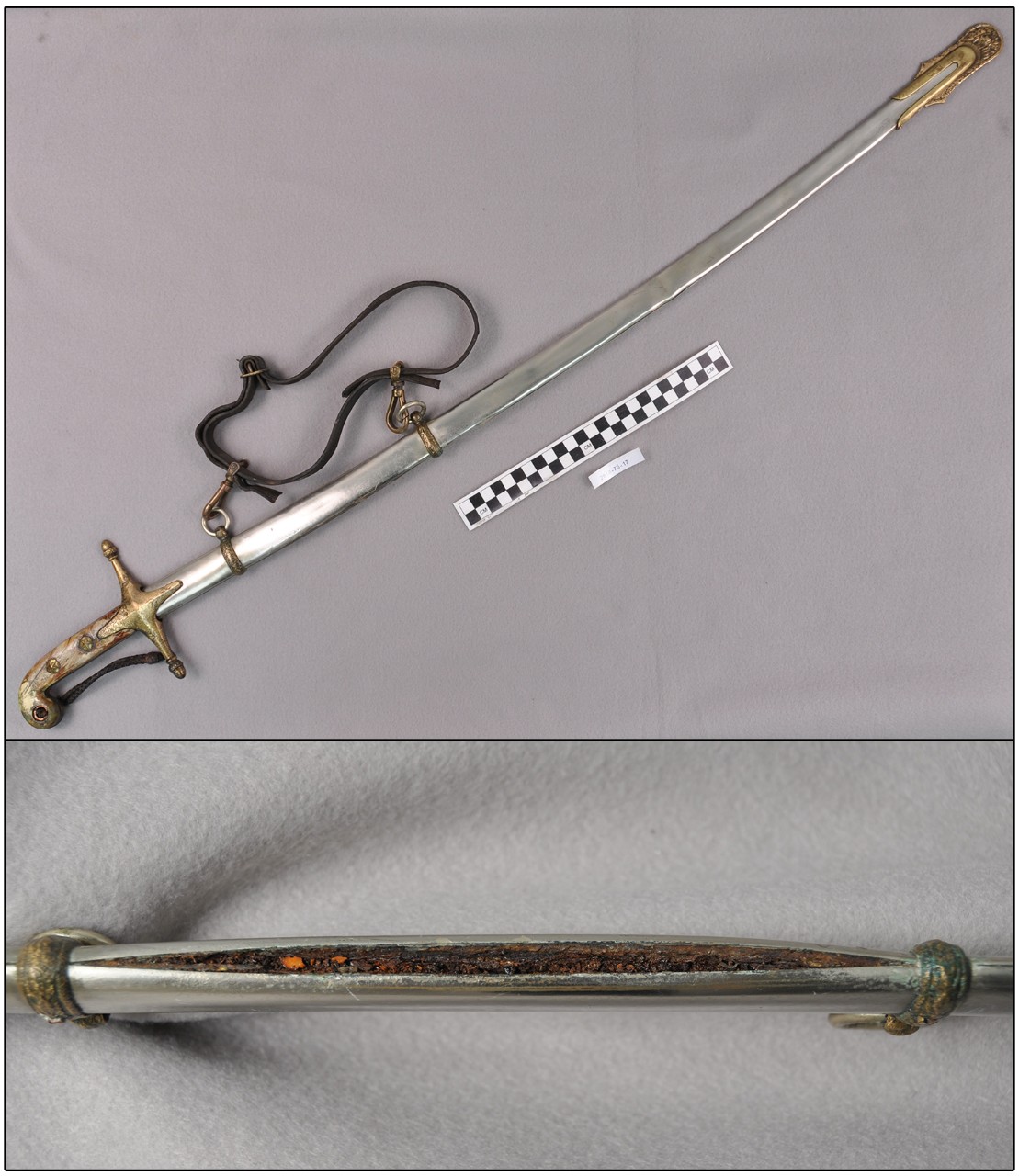 Two color photos of a sword. The top image is the complete sword with a sheath covering the blade and a leather strap attached. The bottom is a close up of a crack in the sheath showing the corroded blade, which is orange and red in color and fla...