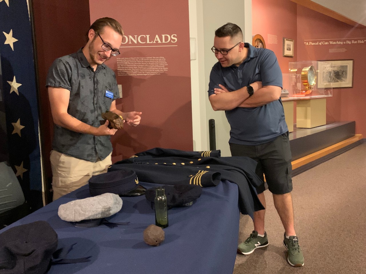 Volunteer staff with Civil War artifacts, teaching a visitor