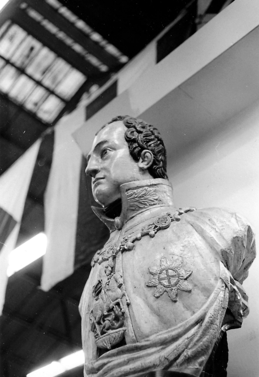 NMUSN-144: Wooden figurehead. This wooden figurehead from the early 19th century bears a striking resemblance to the Prince Regent, who later became King George IV of England. The two decorations on his chest are the Order of St. George and the S...