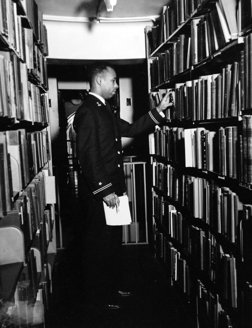 80-G-707012:   Midshipman Wesley Brown, June 1949.   Brown is selecting reference books for first class term paper in the library, released June 3, 1949.  Note, Brown was the first African-American to graduate from the U.S. Naval Academy and served as a Civil Engineer, retiring in June 1969 with the rank of Lieutenant Commander.   Brown died on May 12, 2012.   Official U.S. Navy Photograph, now in the collections of the National Archives.   