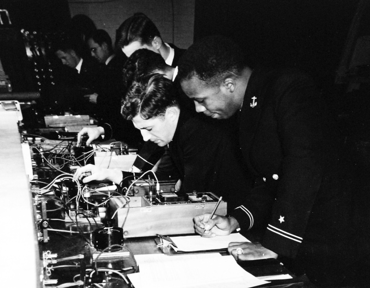 80-G-707015:   Midshipman Wesley Brown, June 1949.   U.S. Naval Academy, Annapolis, Maryland.  Shown:  Laboratory exercise in Electrical Engineering, released June 3, 1949.  In this group is Midshipman Wesley Brown.   Note, Brown was the first African-American to graduate from the U.S. Naval Academy and served as a Civil Engineer, retiring in June 1969 with the rank of Lieutenant Commander.   Brown died on May 12, 2012.   U.S. Navy Photograph, now in the collections of the National Archives.  Note, the image is curved.  