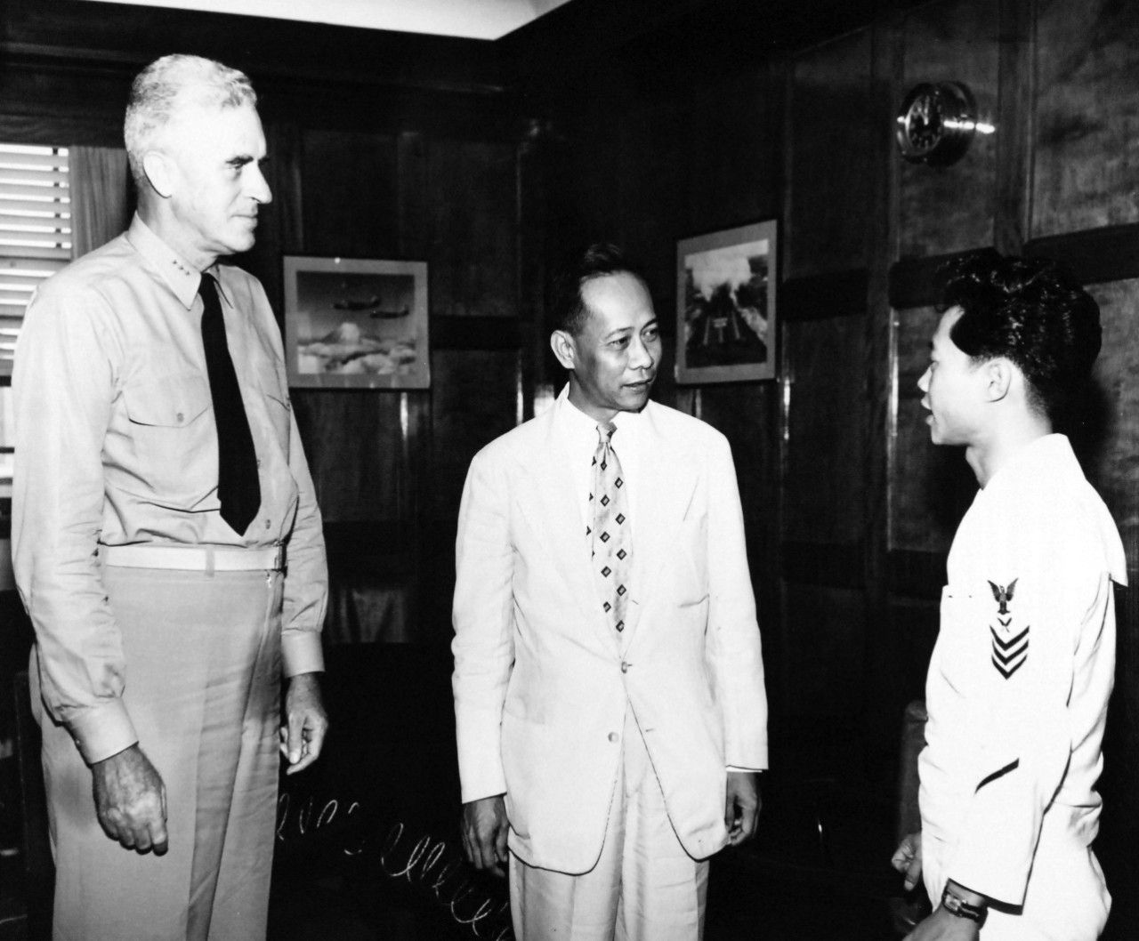 80-G-680509:  YN1 Gertrudo Lim, late 1940s-early 1950s.   Vice Admiral William M. Callaghan, left, introduces YN1 Gertrudo Lim to Dr. Jose F. Imperial, center, Minister to Japan from the Republic of the Philippines when he called at the Admiral’s headquarters.  Lim is attached to Admiral Callaghan’s staff at Yokosuka, Japan.   Official U.S. Navy Photograph, now in the collections of the National Archives.  