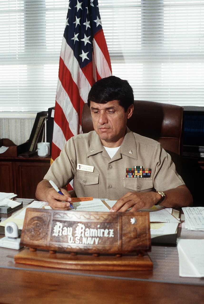 330-CFD-DN-SC-94-02151:   Commander Ray Ramirez, 1993.  Ramirez, Hispanic weapons officer of Naval Air Station, North Island, California, looks over assignments of weapons personnel at this desk in his office.  Photographed on October 1, 1993 by PH1 Steven Cooke.  Official U.S. Navy photograph, now in the collections of the National Archives.  