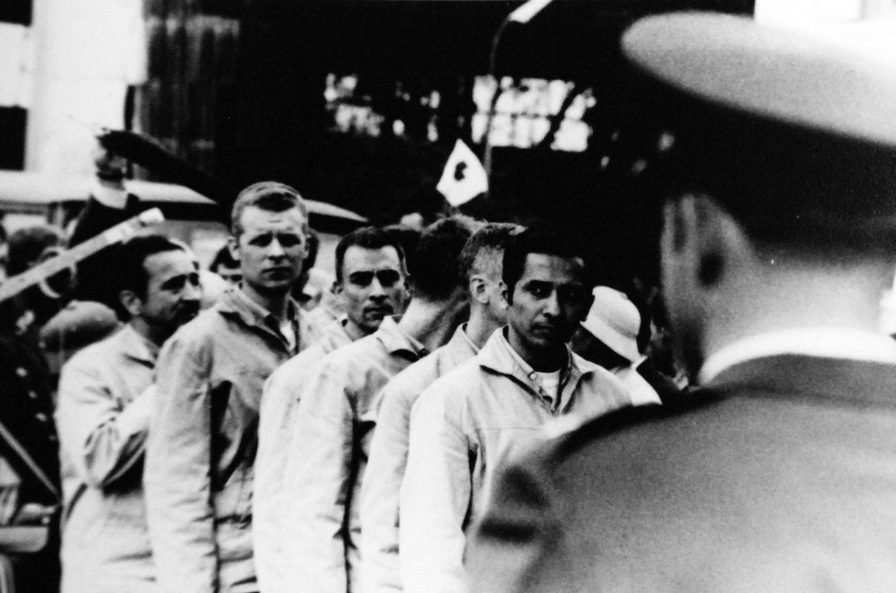 428-GX-USN 1155656:  American Prisoners of War, 1973.   Hanoi, North Vietnam.  Lieutenant Colonel Richard F. Abel, USAF, foreground, public affairs officer greets the first group of prisoners of war as the men wait for their names to be announced prior to their boarding a C-141A “Starlifter” cargo transport aircraft at Gia Lam Airport.  Lieutenant Commander Everett Alvarez, Jr., USN, heads the line, February 1973.  Official U.S. Navy photograph, now in the collections of the National Archives. 