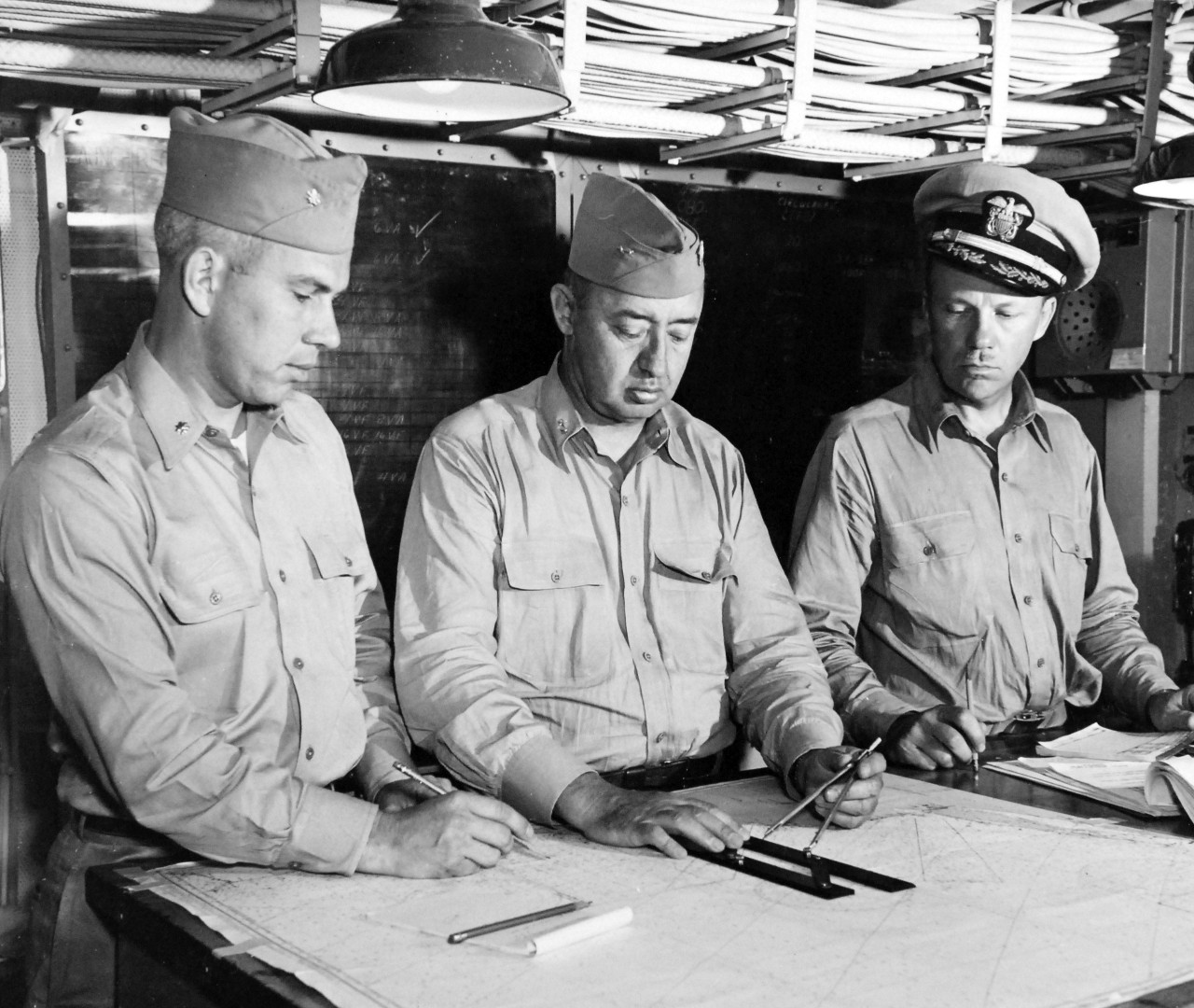 80-G-419159:  Rear Admiral Joseph J. Clark onboard USS Kearsarge (CV-33), July 1949.   Left to right: Lieutenant R.E. Merchant; Rear Admiral J. J. Clark; and Captain P. Henry discussing operations during reserve training cruise held onboard, July 6, 1943.     Official U.S. Navy Photograph, now in the collections of the National Archives.   