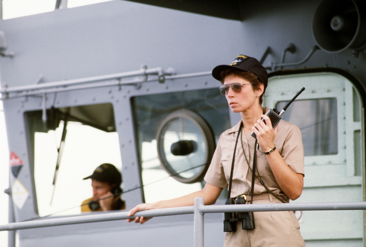 330-CFD-DN-ST-88-01116:   Master Chief Storekeeper Alicia Aitken,  1988.   Aitken was the senior enlisted advisor aboard the salvage ship USS Grapple (ARS-53), supervises a working party on the fantail.  The Grapple is towing three minesweepers to the Persian Gulf to support U.S. Navy escort operations.   Official U.S. Navy photograph, now in the collections of the National Archives.  