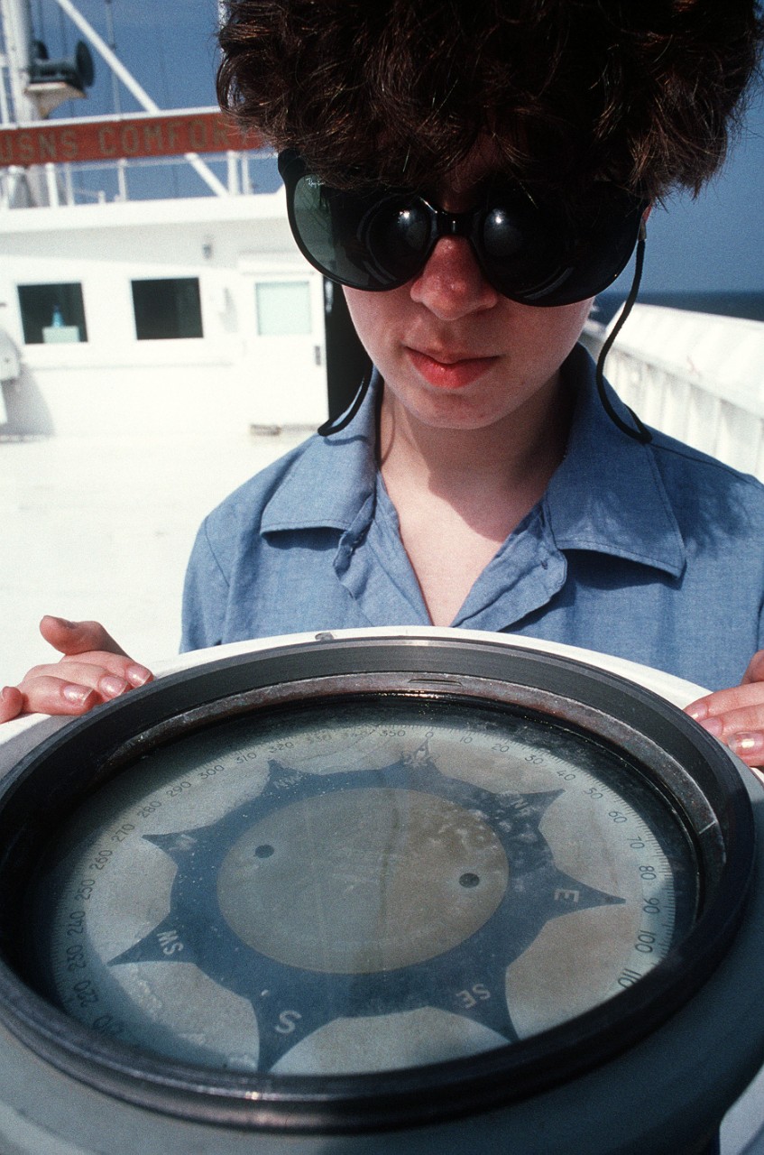 330-CFD-DN-ST-91-07837:     U.S. Navy female sailor, 1991.   A  female crew member looks at the compass on the deck of the hospital ship USNS Comfort (T-AH-20) during Operation Desert Storm.  Official U.S. Navy photograph, now in the collections of the National Archives.  