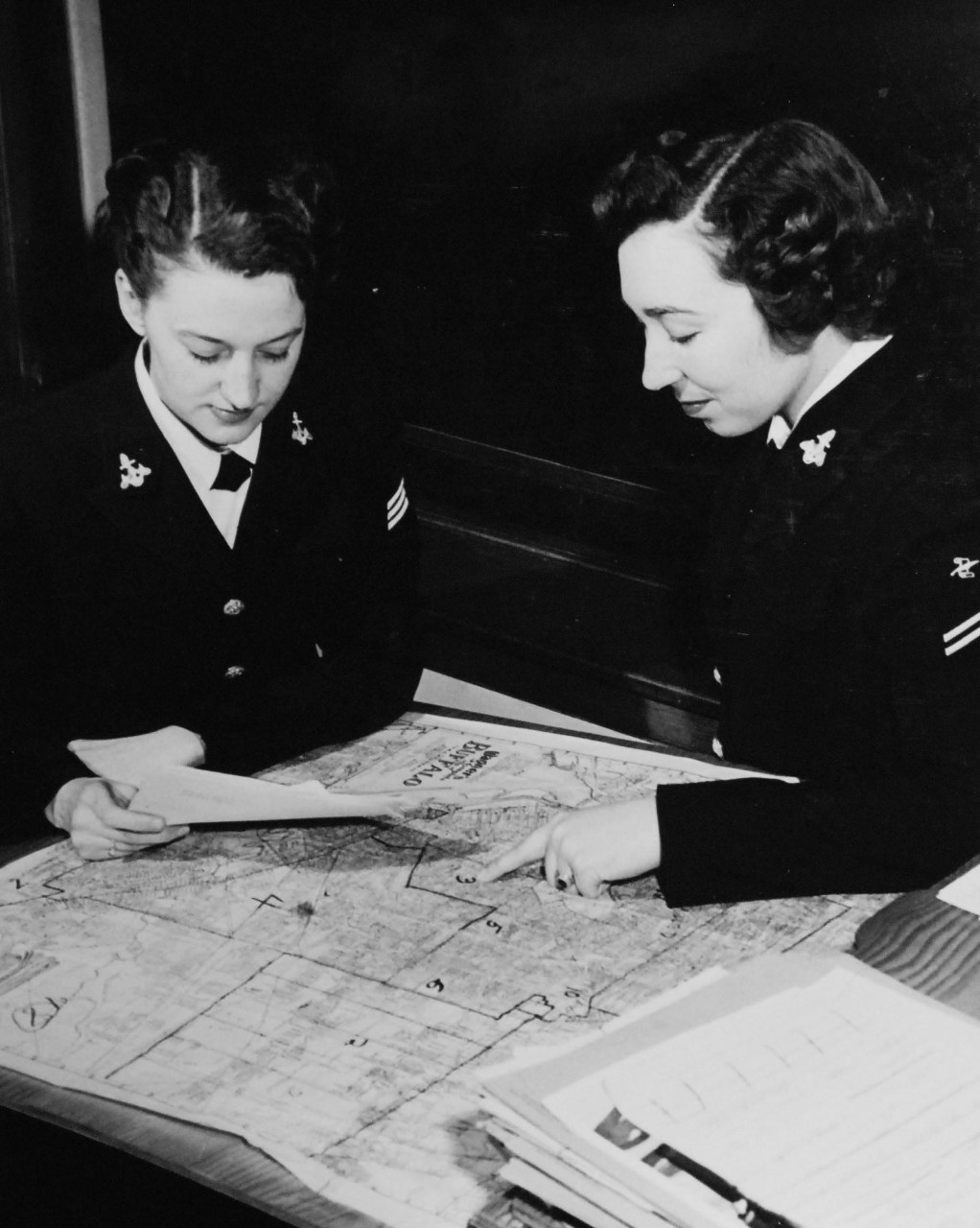 80-G-428486:   WAVES at Fleet Hometown News Center, Naval Training Center, Great Lakes, Illinois, May 1951.    Seaman Shirley L. Macdonald and Seaman Apprentice Elizabeth (?) pinpoint the news.  They are locating areas in cities in order to send news items to community newspapers.   Official U.S. Navy photograph, now in the collections of the National Archives. 