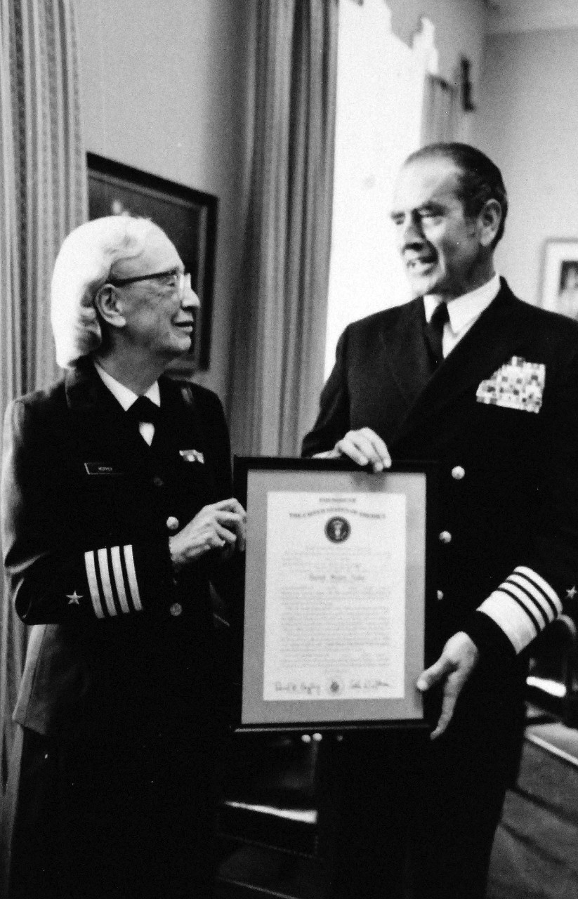428-GX-USN 1157764:  Captain Grace Hopper, August 1973.   Pentagon, Washington.  Admiral Elmo R. Zumwalt, Jr., USN, Chief of Naval Operations, presents a certification of promotion to the rank of Captain to Commander Grace Hopper, Head of Programming Language Section of the Naval Information Systems Division (OP 91).  Captain Hopper was the first Naval Reserve woman to be called back to active duty.    Photographed by Bill Mason, August 13, 1973.  Photographed from small reference card.  Official U.S. Navy Photograph, now in the collections of the National Archives.  