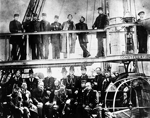 NH 91725:   USS Constellation (1855-1953), officers pose with welcoming officials at Cork, Ireland, upon her arrival with Irish relief supplies, 1880.   NHHC Photograph Collection. 