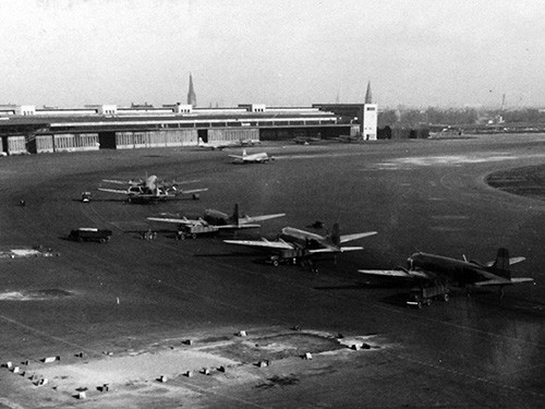 80-G-707099: Berlin Airlift. R5-D airlift carriers arrive at Tempelhof Air Base, Berlin, April 1949. Official U.S. Navy Photograph, now in the collections of the National Archives photograph